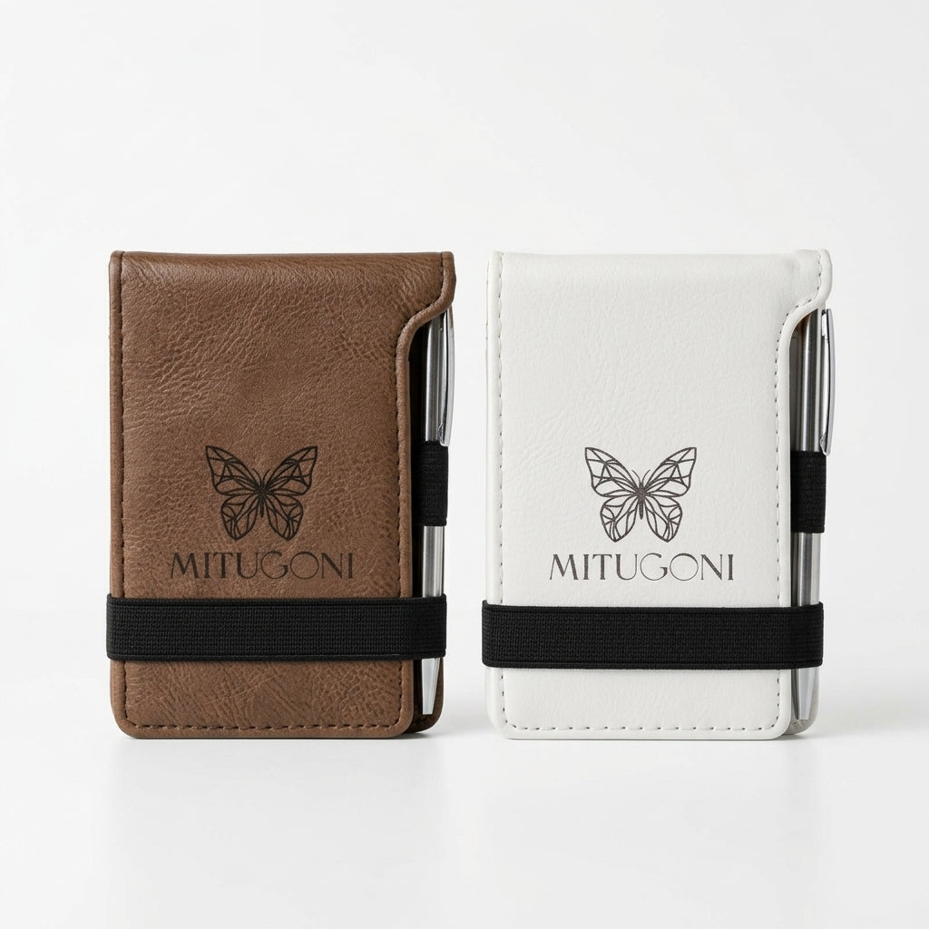 White notebook with black butterfly design and 'MITUGONI' branding on a dark gray background