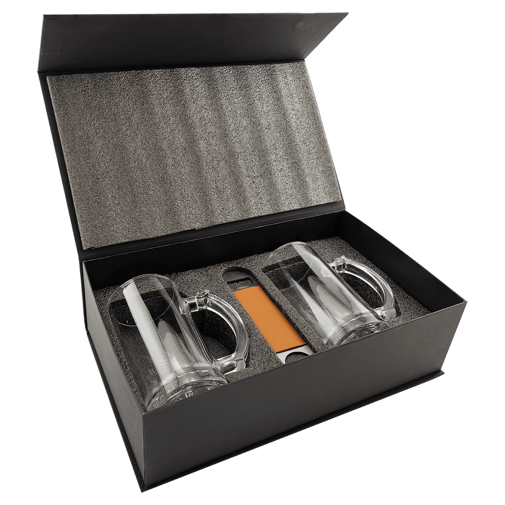 Set of glass tumblers with a knife and orange item in a black box on a white background