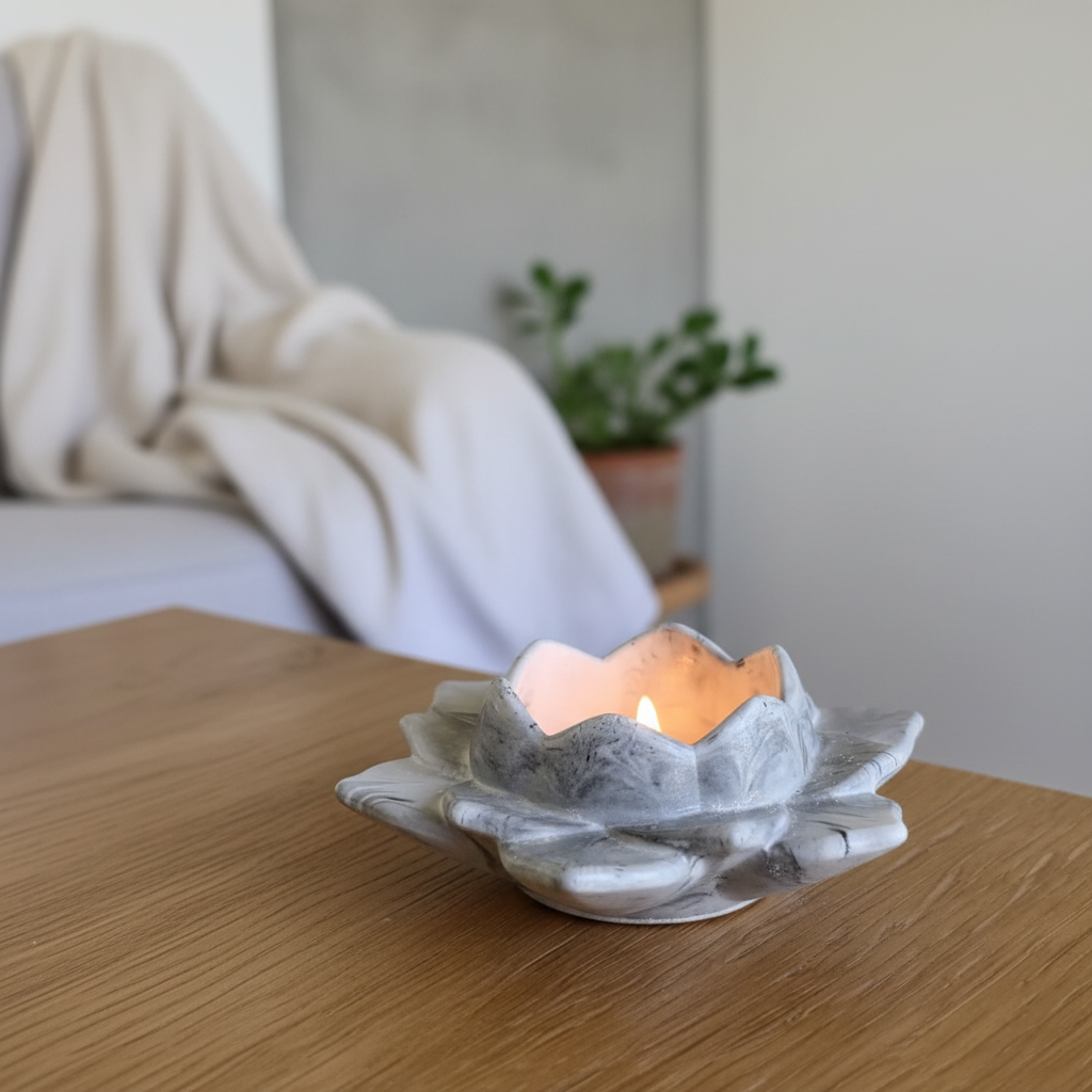 Decorative candle holder with a lit candle on a wooden surface, blurred background