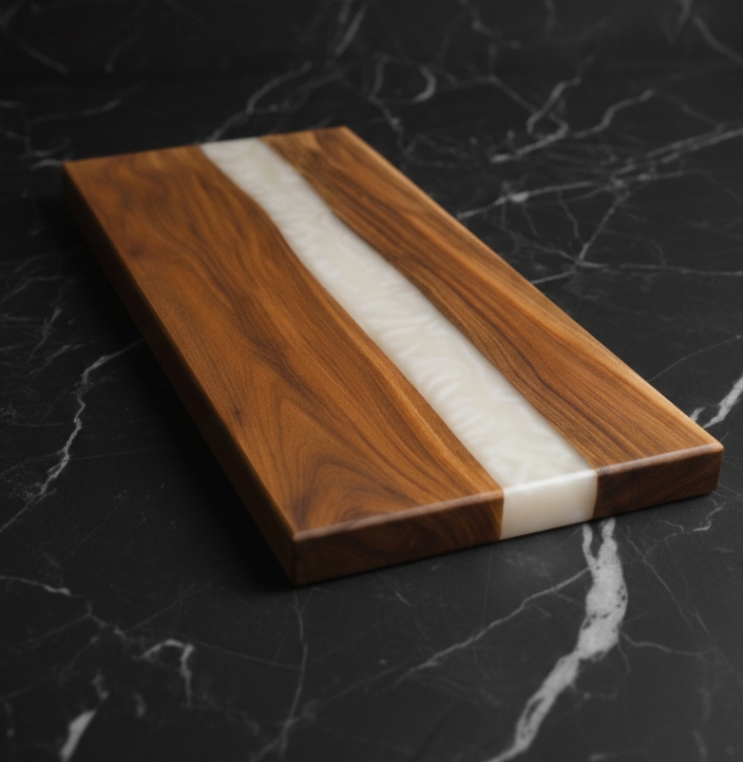 Wooden cutting board with a white stripe on a black marble surface